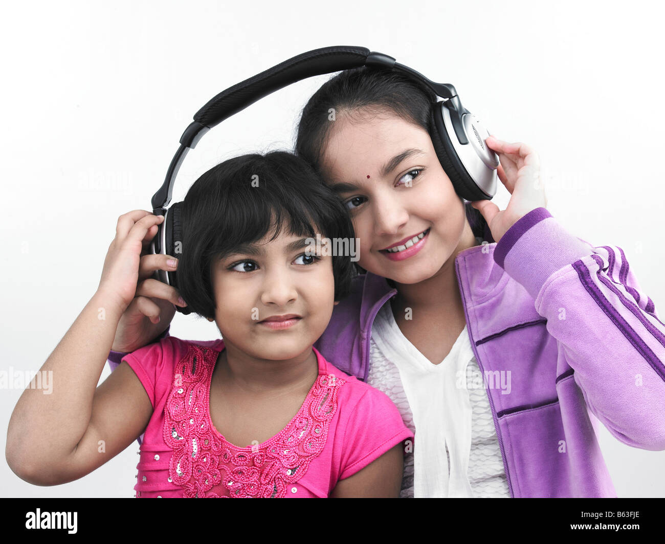 Porträt von zwei asiatischen Schwestern anhören von Musik Stockfoto