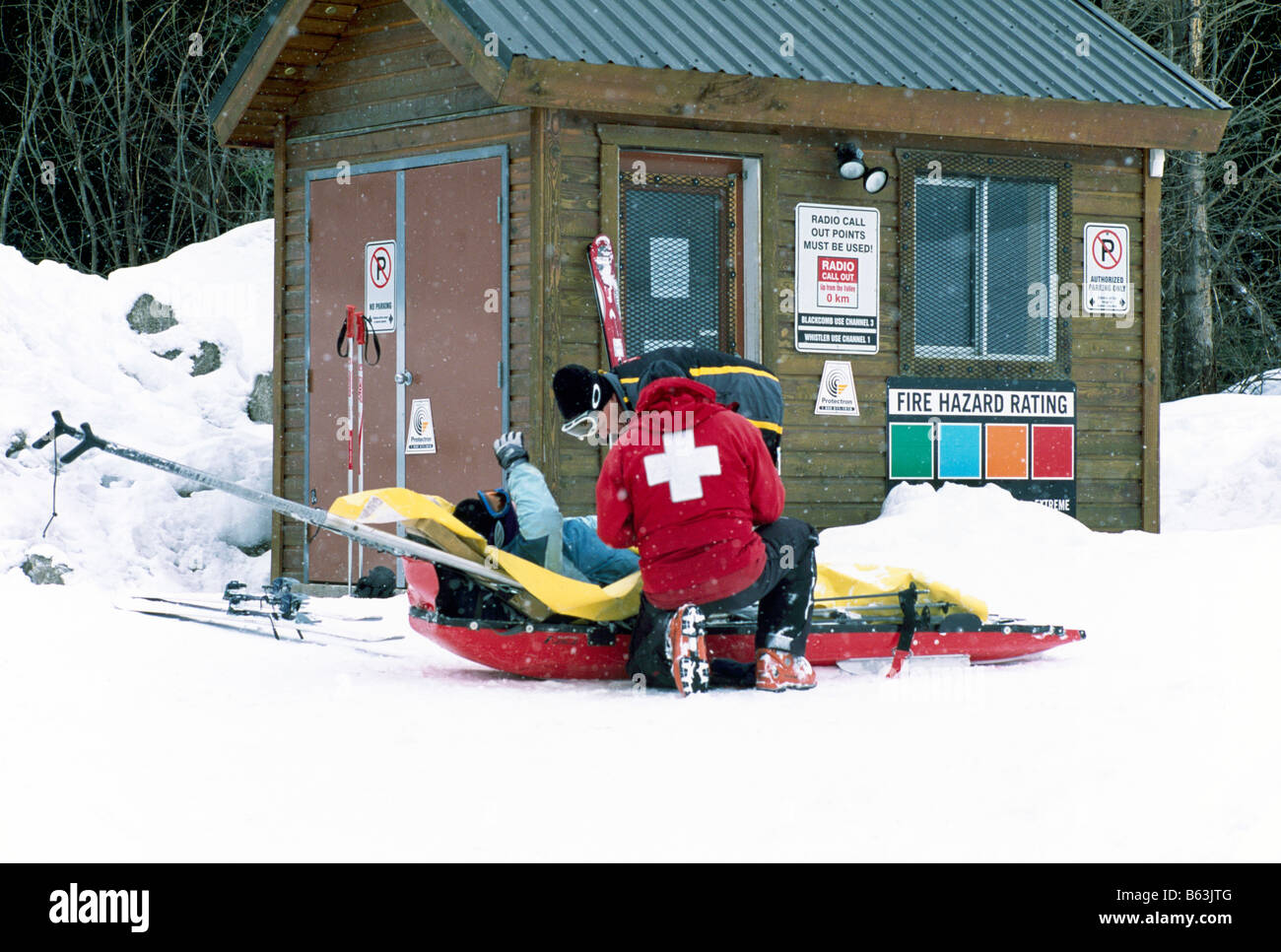 Erste Hilfe Sicherheit Ski Patrol Sanitäter kümmern sich um ein Skifahrer in einem Ski-Unfall verletzt Stockfoto