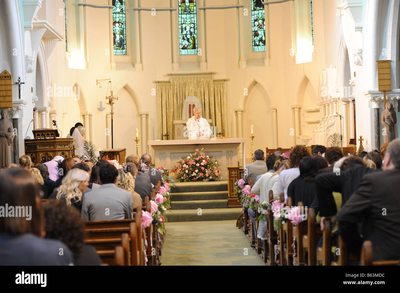 Ein Priester führt eine Trauung in einer katholischen Kirche Stockfoto
