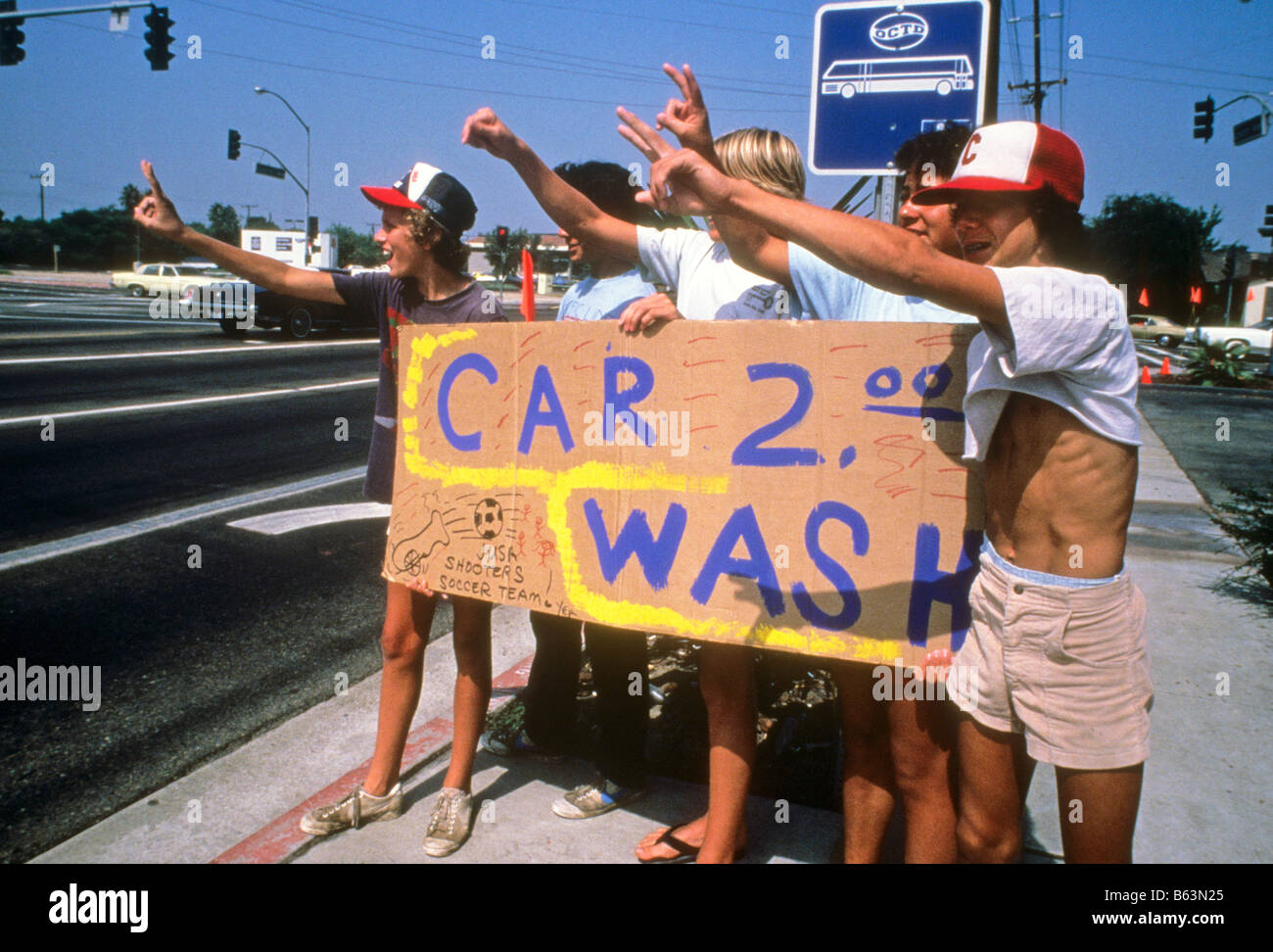Teenie jungen halten Zeichen Förderung Autowäsche, Gelder für ihre Fußball-Team-Lieferungen. Stockfoto