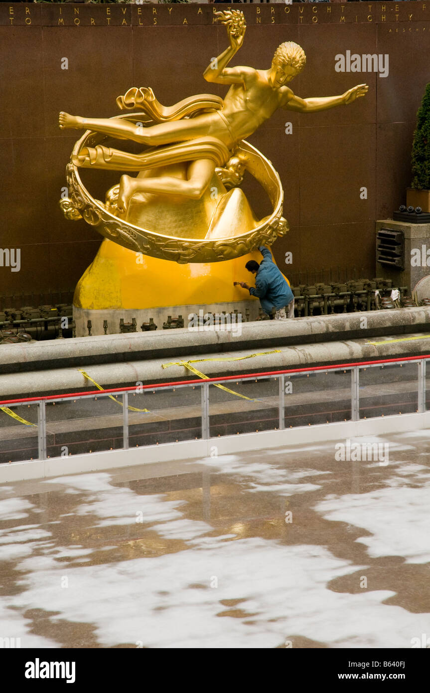 Ein Mensch malt die Statue von Prometheus am Rockefeller Center in Manhattan, New York, USA. Stockfoto