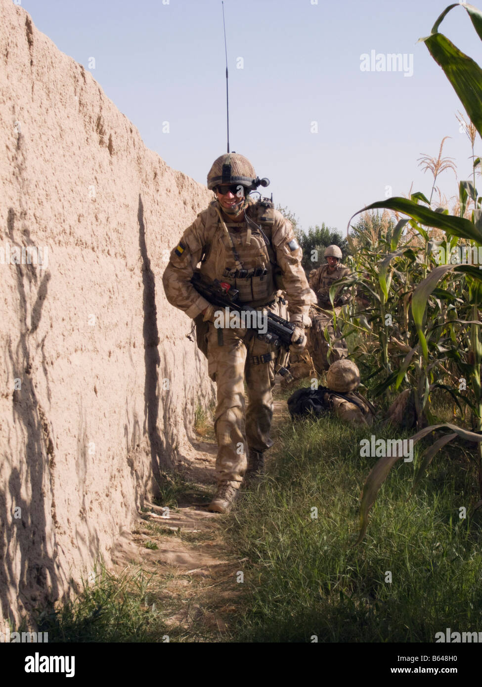 Britischer Offizier auf Patrouille in Helmand Provinz laufen mit SA80, underslung Granatwerfer, Helm und Körper Rüstung. Stockfoto