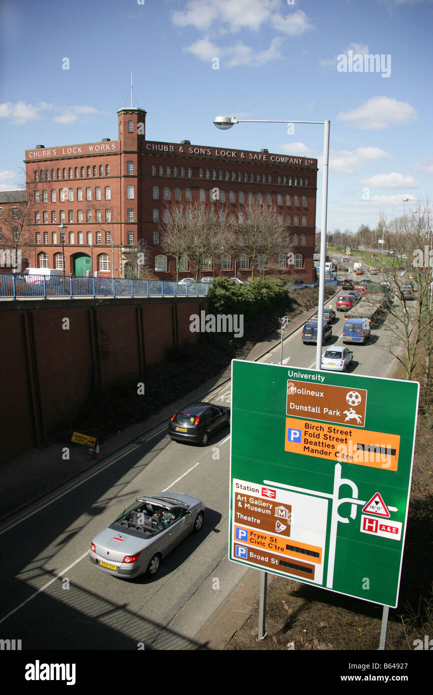 Stadt von Wolverhampton, England. Wolverhampton Stadtzentrum Richtung Straßenschild mit der ehemaligen Chubb-Fabrik im Hintergrund. Stockfoto