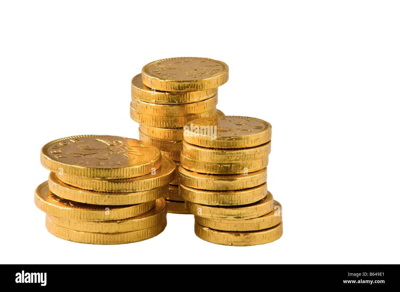 Ein Haufen von Schokoladen-Münzen in Goldfolie vor einem weißen Hintergrund. Stockfoto