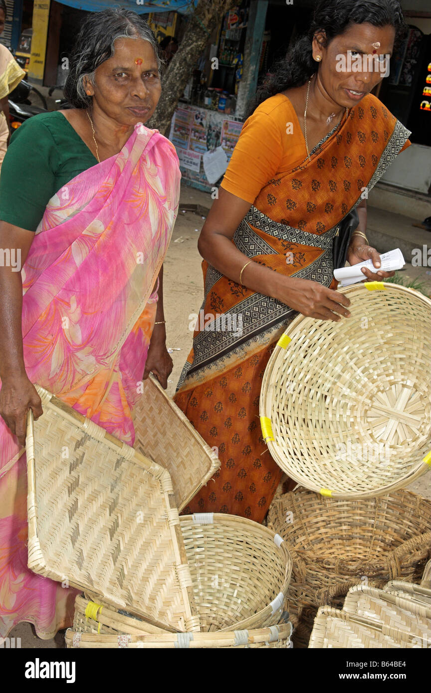 Zwei indische Frau in Saris Prüfung gewebt Körbe, Kerala Indien kaufen Stockfoto