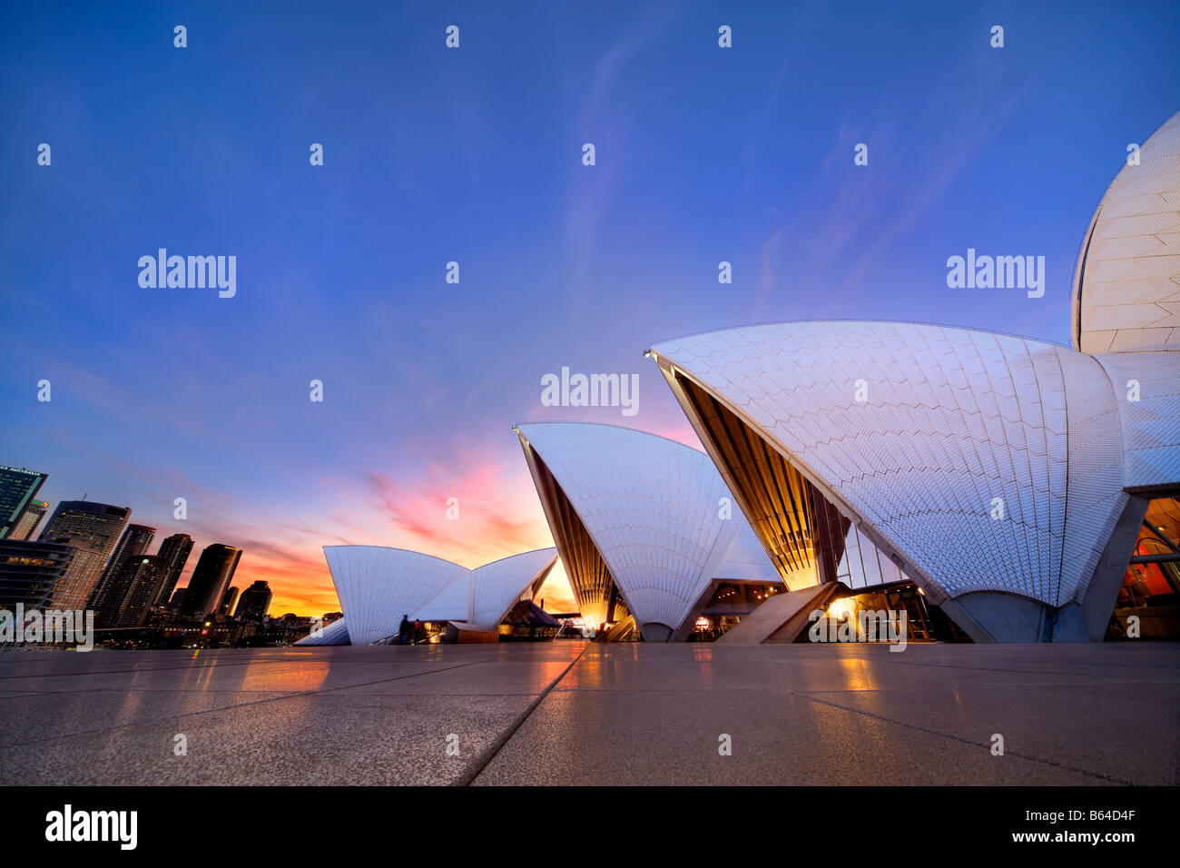 Sydney Opera House mit der Innenstadt von Sydney bei Sonnenuntergang. Sydney Australien Stockfoto