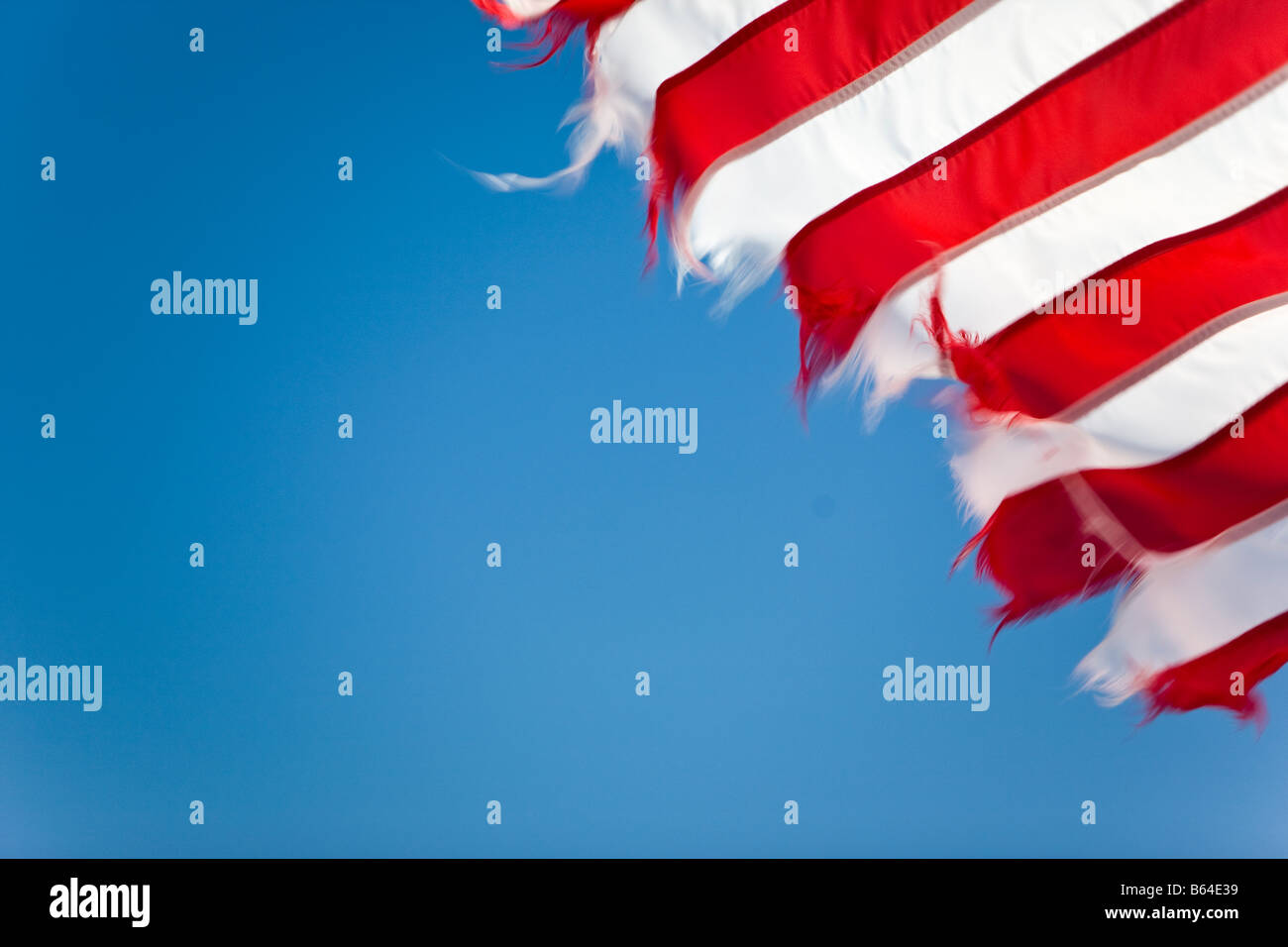 Ein Stück der amerikanischen Flagge im Wind gegen ein strahlend blauer Himmel Stockfoto