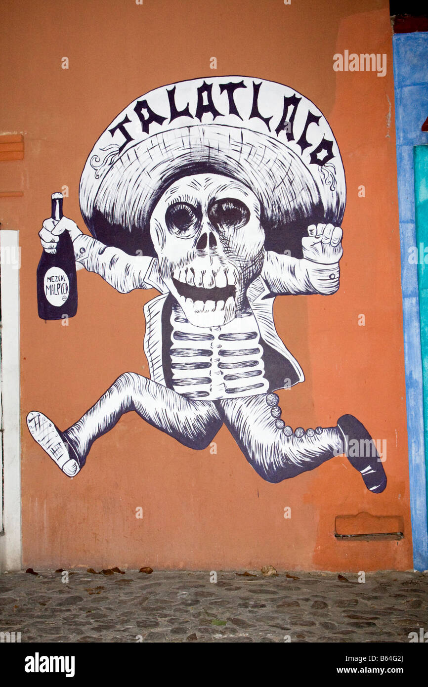 Oaxaca, Mexiko. Tag der Toten. Wandmalerei der laufenden Skelett Holding eine Flasche Mezcal, eine lokale alkoholische Getränke. Stockfoto