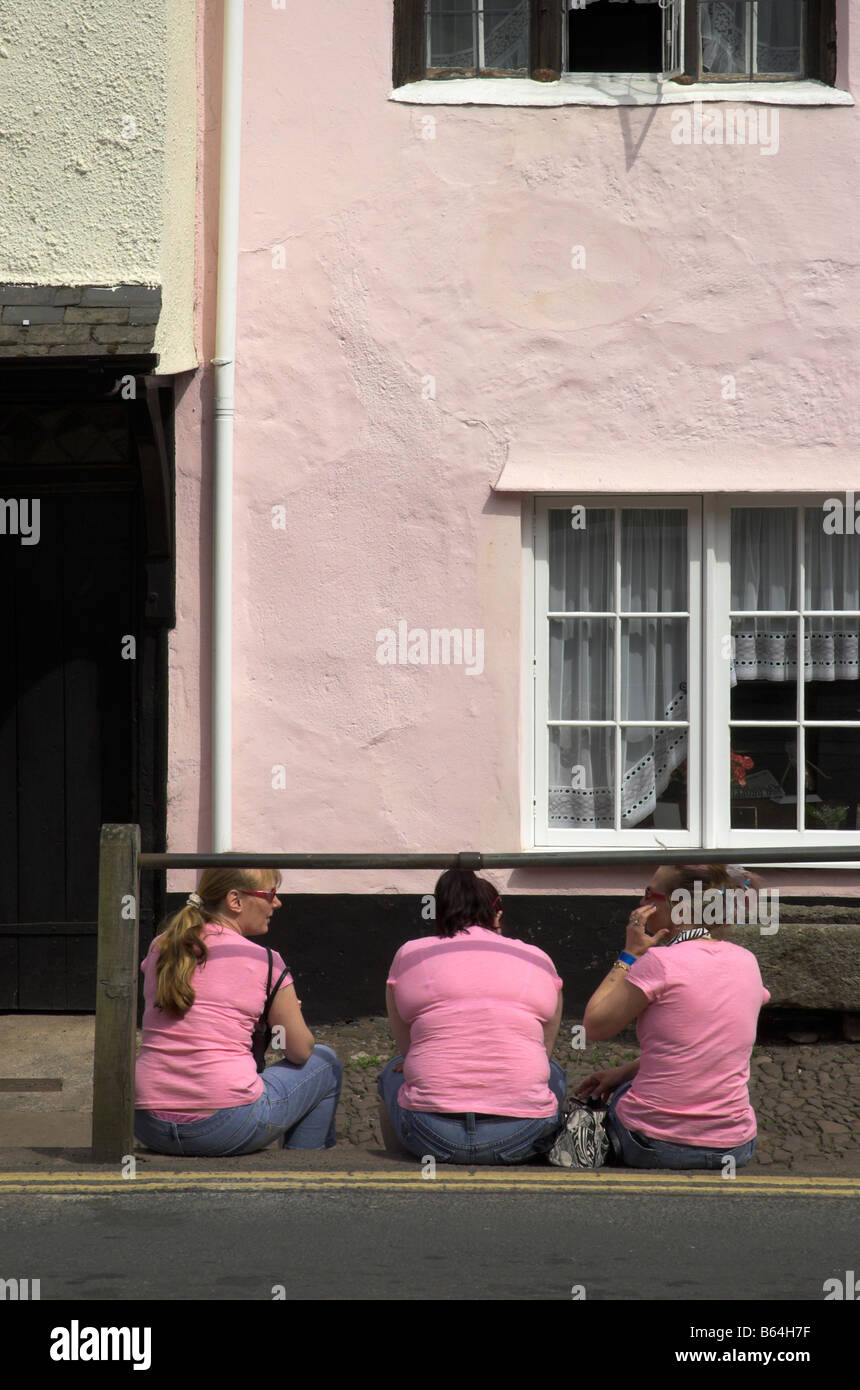 Drei Frauen in rosa saß an der Straße identisch gekleidet Stockfoto