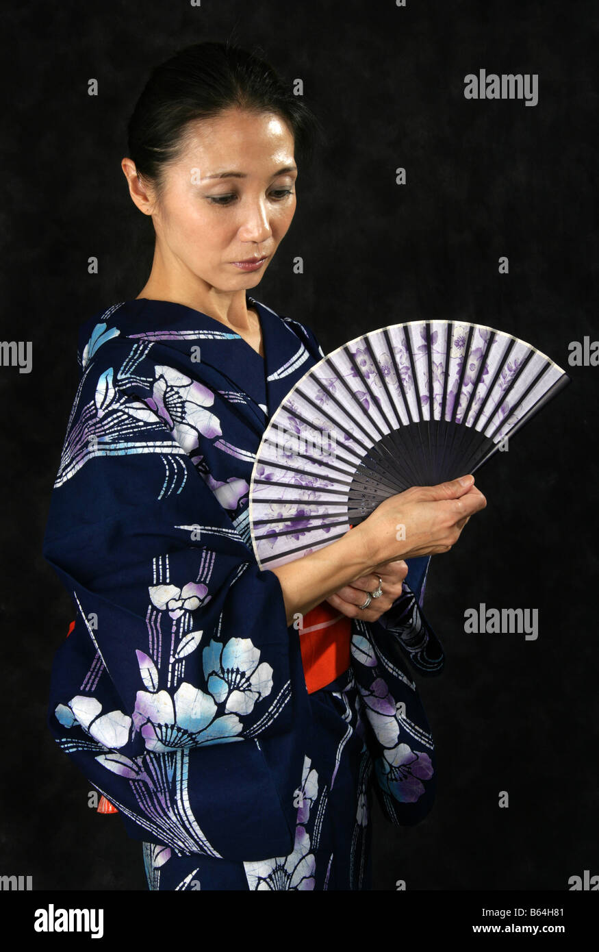 Japanische Frau in einem blauen Kimono mit einem Ventilator Stockfoto