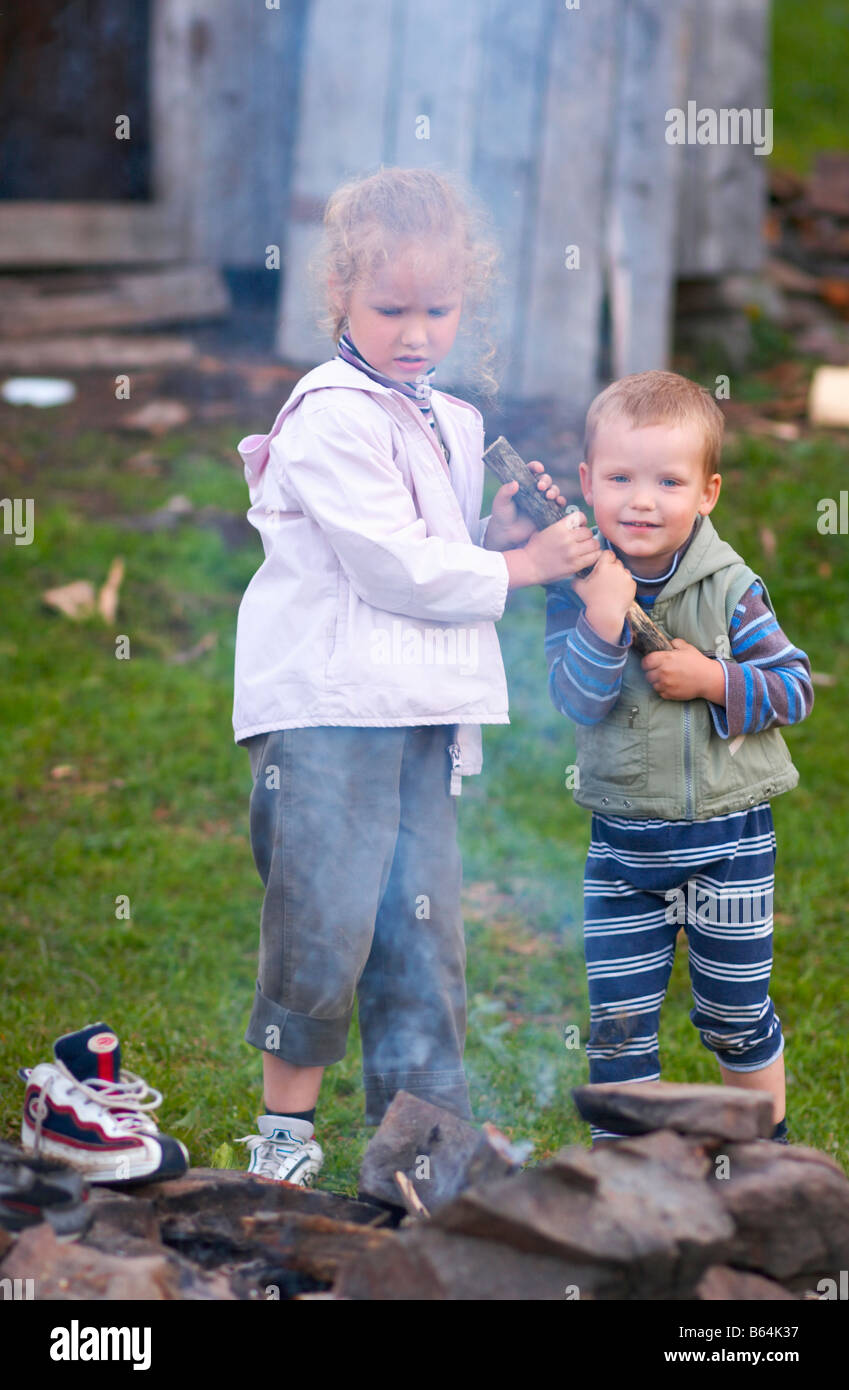 zwei kleine Kinder der Rivalität in der Nähe von Lagerfeuer Stockfoto