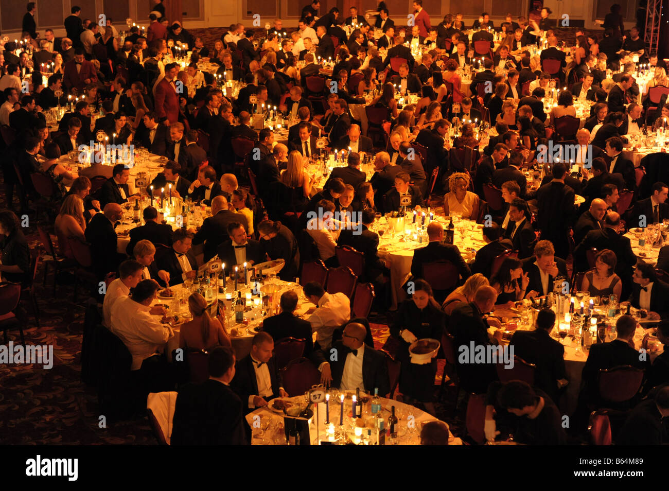 Große Gruppe von Menschen, die am Abend formelle schwarze Krawatte Veranstaltung an Tischen sitzen. Intelligente Gala-Dinner, erhöhten Blick. Stockfoto