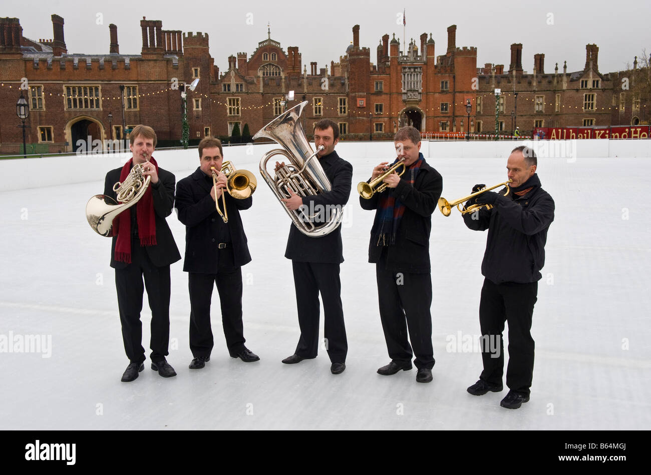 Musiker des Philharmonia Orchestra spielen ein Weihnachtslied auf der Eisbahn eingerichtet, auf dem Gelände des Hampton Court Palace Stockfoto