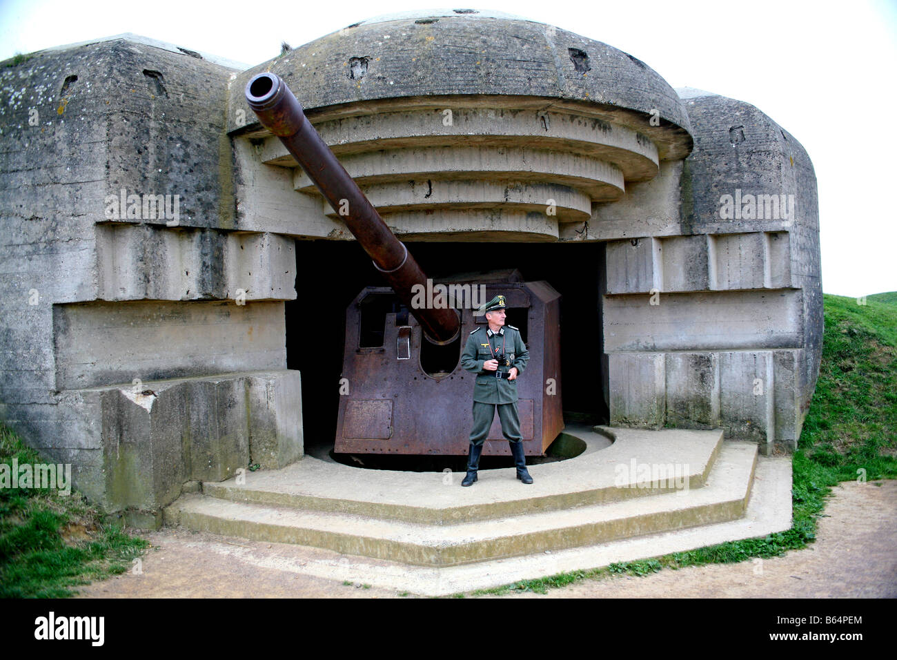 Ein Schauspieler verkleidet als ein deutscher Offizier, Blick über den Ärmelkanal, aus einer deutschen D-Day Pistole Batterie in Normandie Frankreich Stockfoto