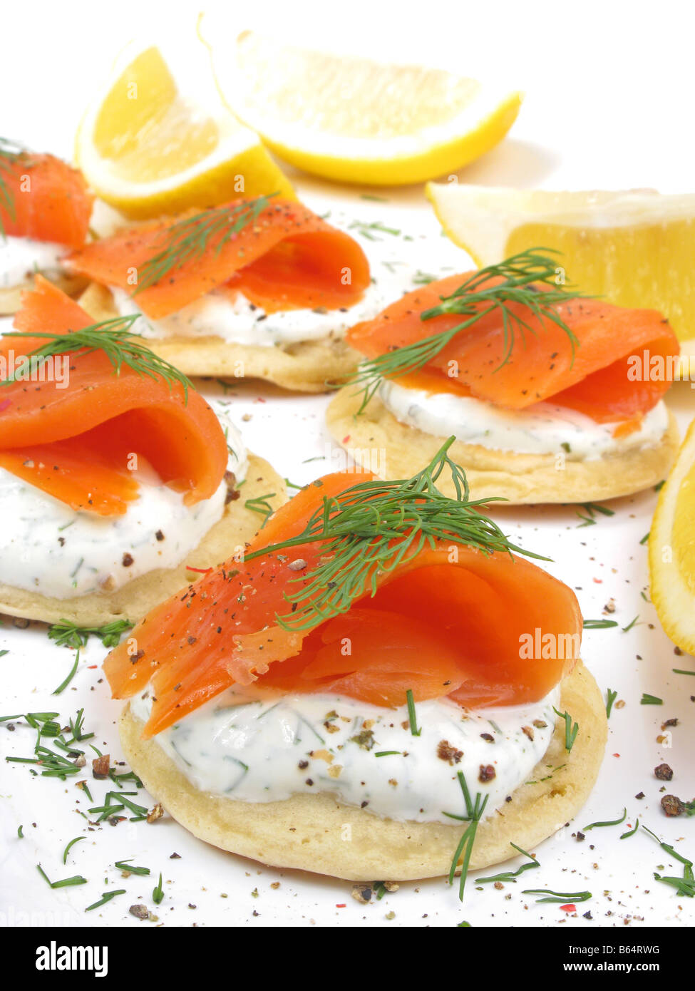 Häppchen von Wild Alaskan Coho Räucherlachs auf Blinis mit Sauerrahm und Dill. Stockfoto