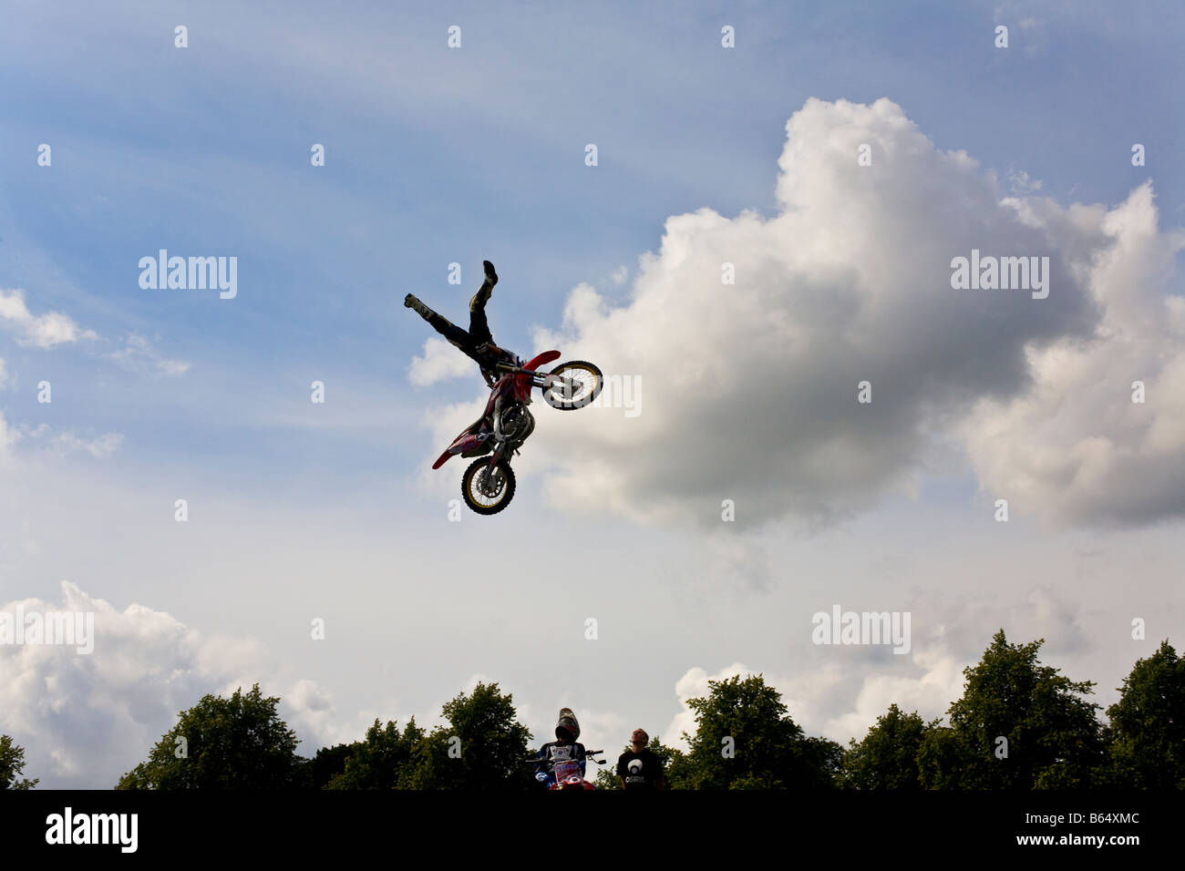 Motorrad-Stuntfahrer Mitte Luft oberhalb der Baumgrenze Stockfoto