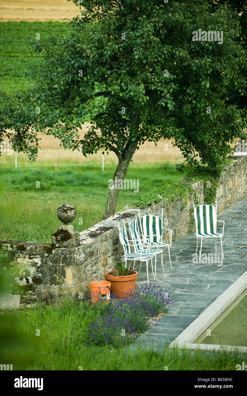 Garten mit Stühlen in der Nähe von Schwimmbad Stockfoto