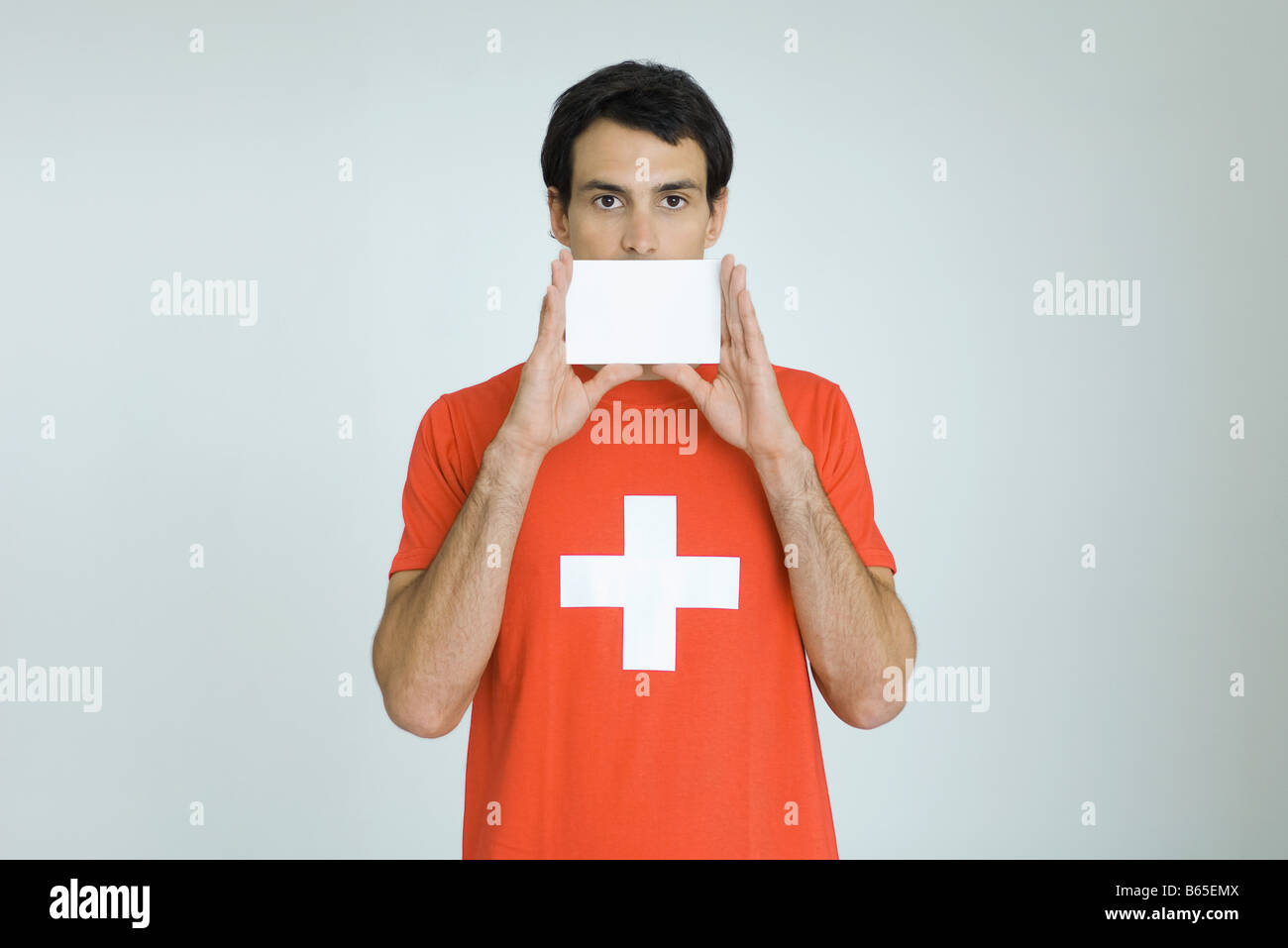 Mann mit Schweizer Flagge t-Shirt, leere Karte vor Mund halten Stockfoto