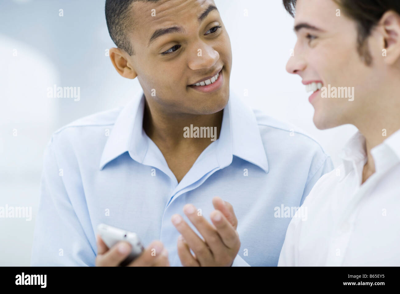 Zwei junge Unternehmer im Chat, eine Holding-Handy Stockfoto