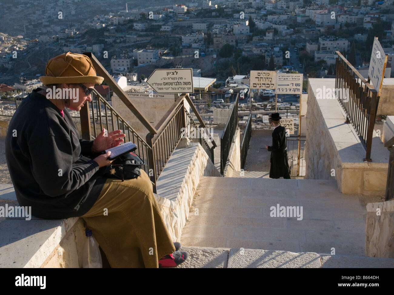 Israel Jerusalem Mount Of Olives Judenfriedhof religiöse Frau sitzen und lesen psalmes Stockfoto