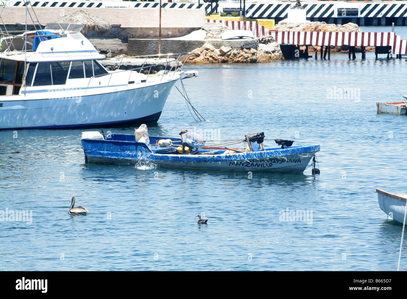 Ein Mann Rettung Wasser aus einem Fiberglas-Fischerboot Stockfoto