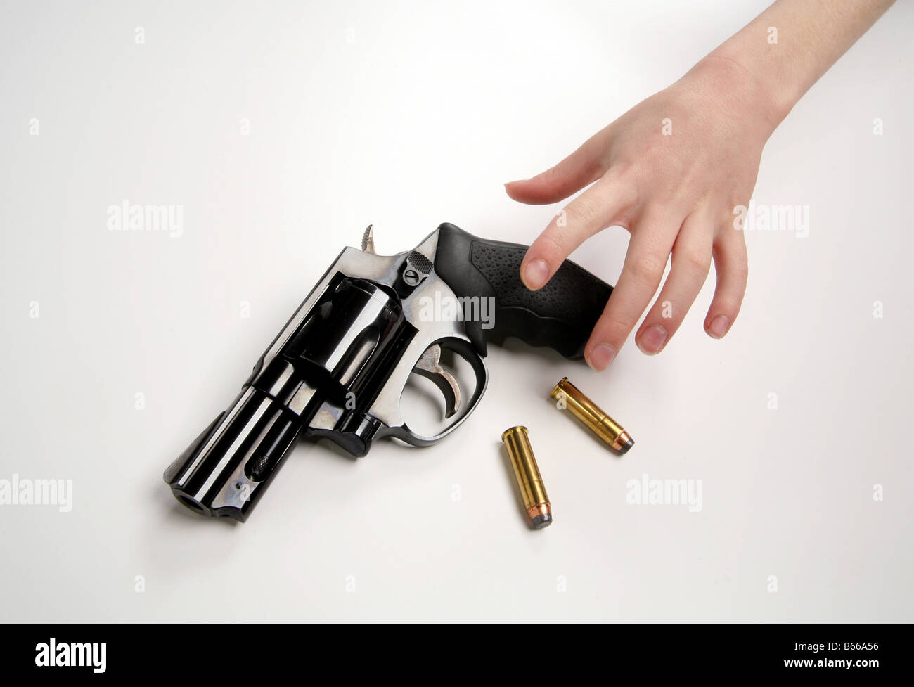 Kind an der Hand Griff nach einer Waffe und Kugeln Stockfoto