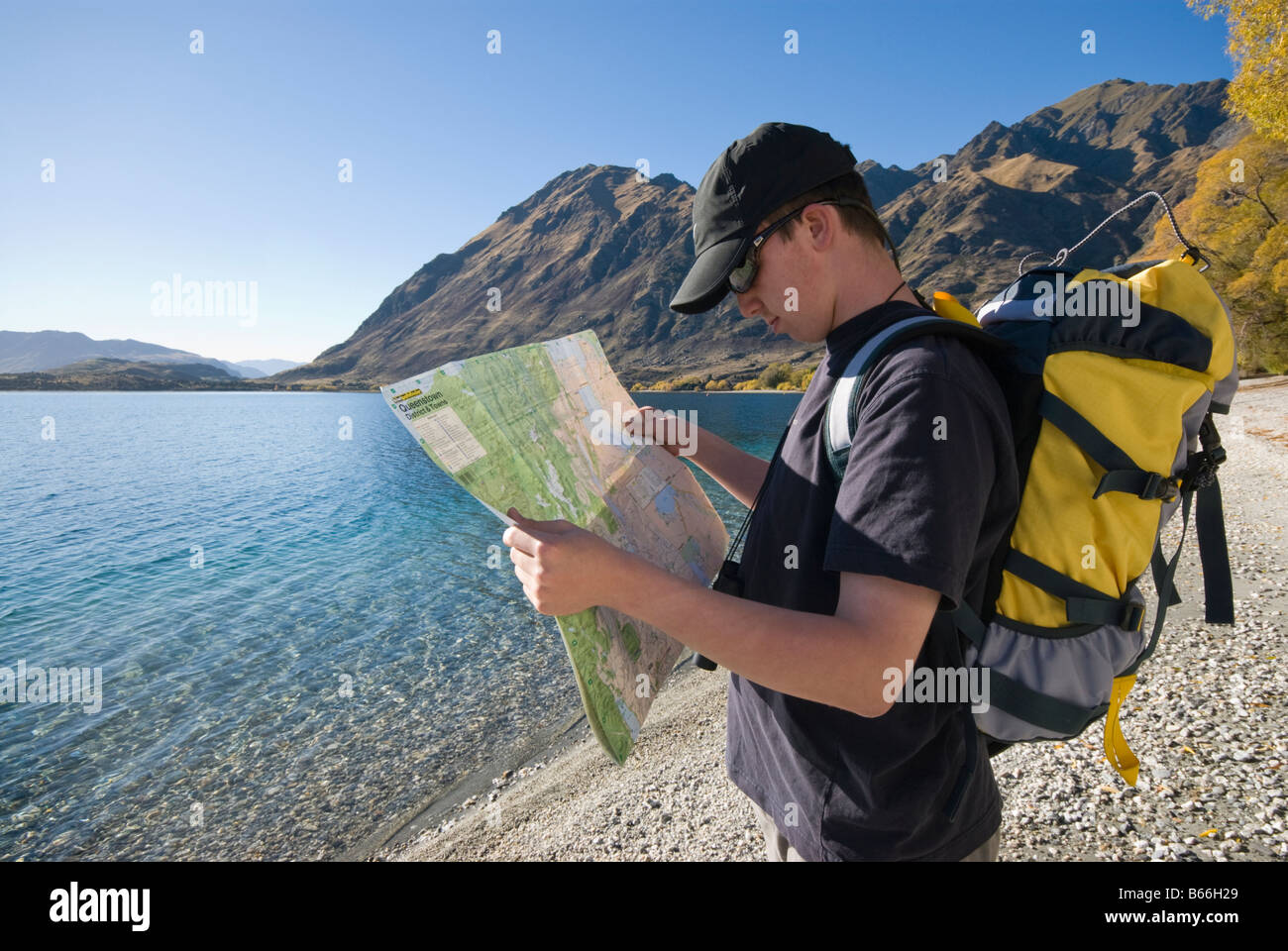 Junge Wanderer Kartenlesen Glendhu Bay am Ufer des Lake Wanaka Stockfoto
