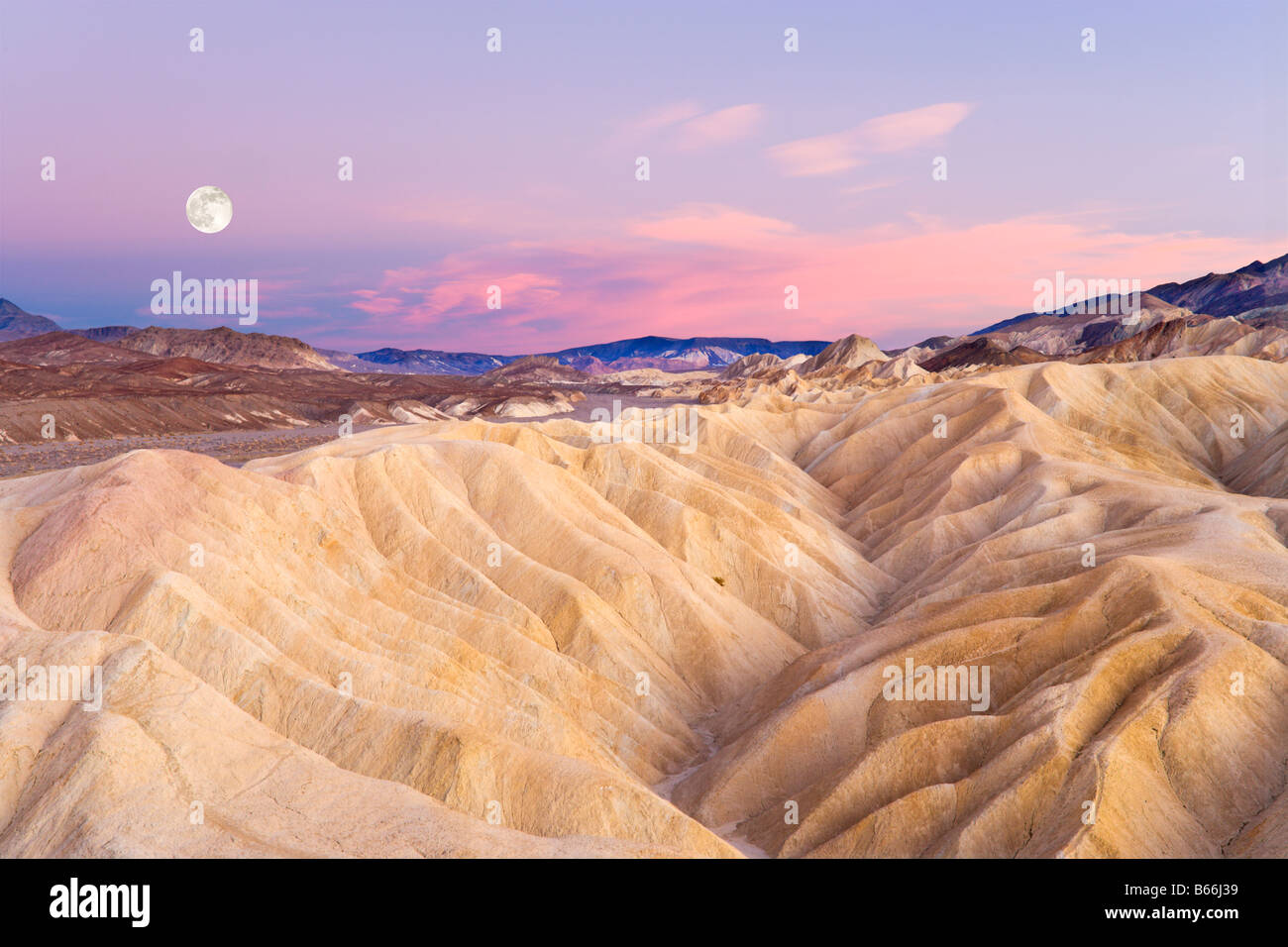 Vollmond bei Sonnenuntergang, Blick nach Osten am Zabriskie Point, Death Valley Nationalpark, Kalifornien, USA Stockfoto