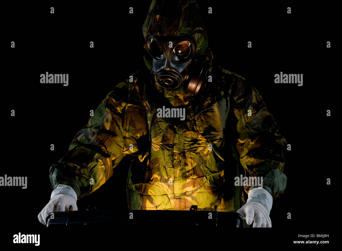 Soldat im Schutzanzug öffnet Fall mit glühenden Substanz im Inneren Stockfoto