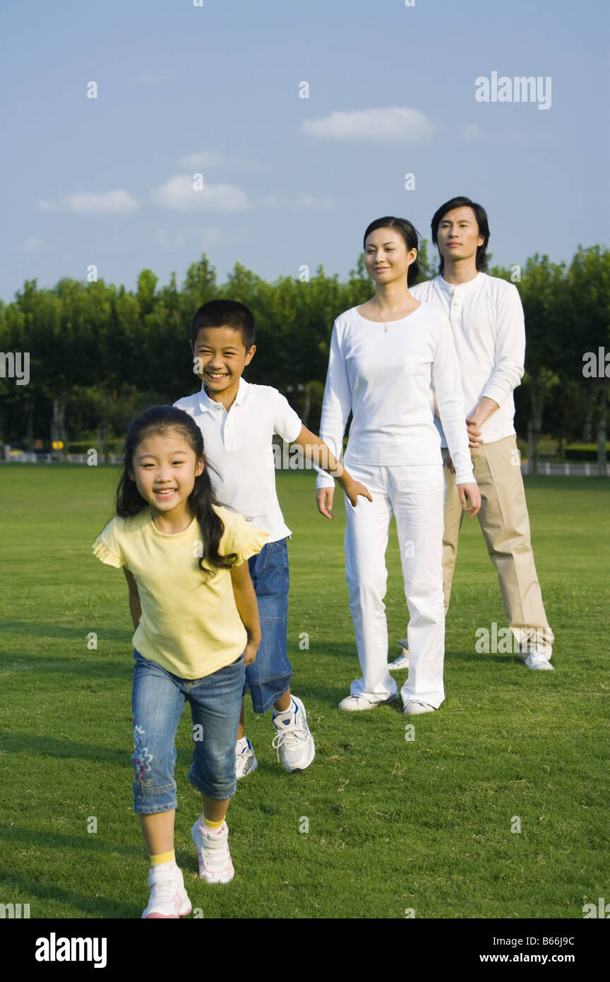 Junge Familie mit zwei Kindern glücklich auf dem Rasen stehen Stockfoto