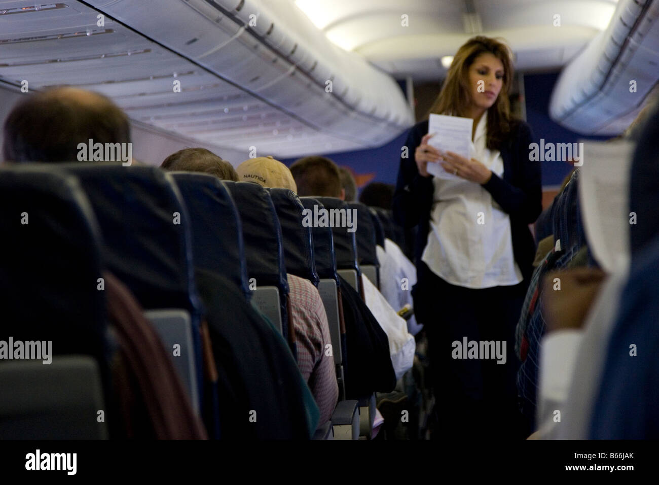 Flight Attendant unterstützt Passagiere auf kommerziellen Flug Stockfoto
