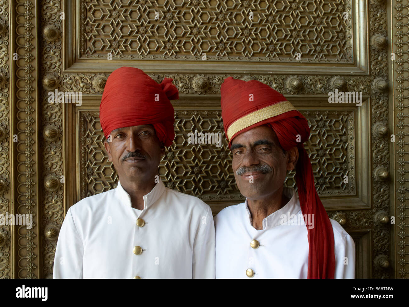 Zwei Wachen tragen rote Turbane und weiße Tuniken im City Palace in der  indischen Stadt Jaipur posieren für die Kamera Stockfotografie - Alamy