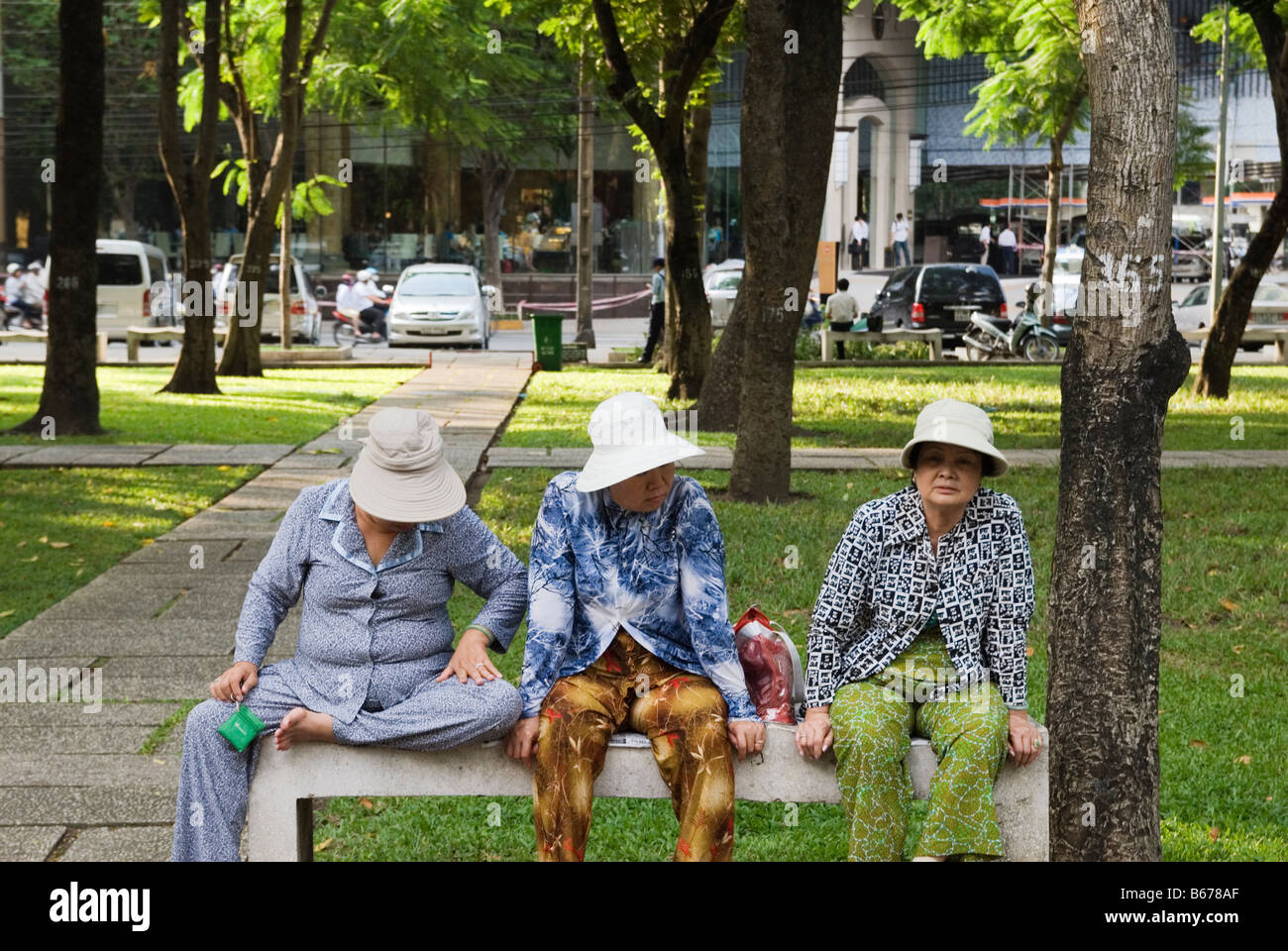 Drei Vietnamesische Damen saß auf einer Parkbank in Ho Chi Minh City, Vietnam Stockfoto