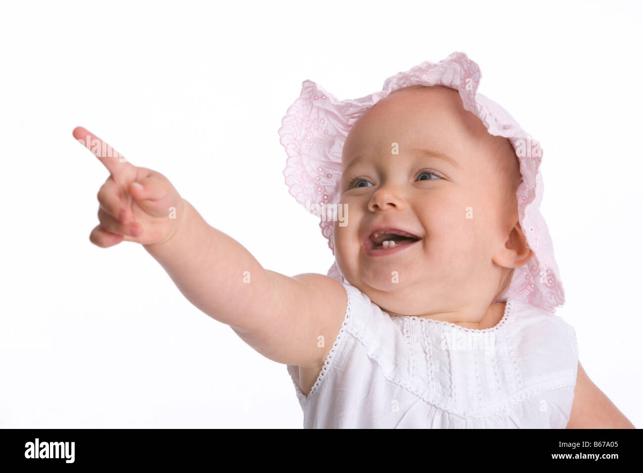 Lächelndes Babymädchen zeigen mit dem finger Stockfoto