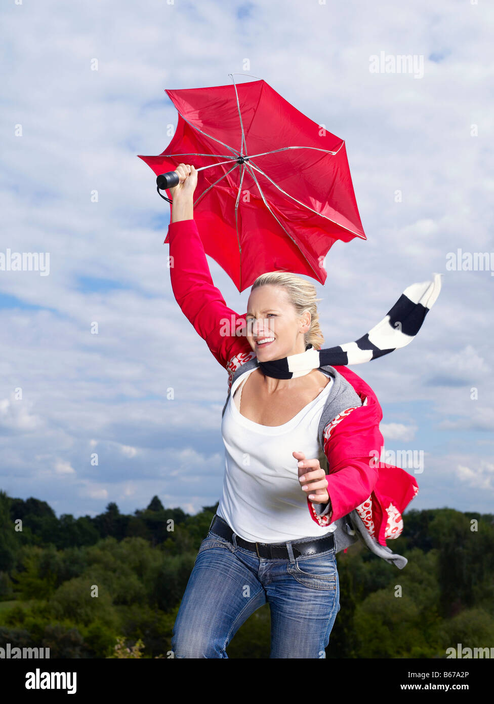 Frau festhalten Regenschirm im wind Stockfoto