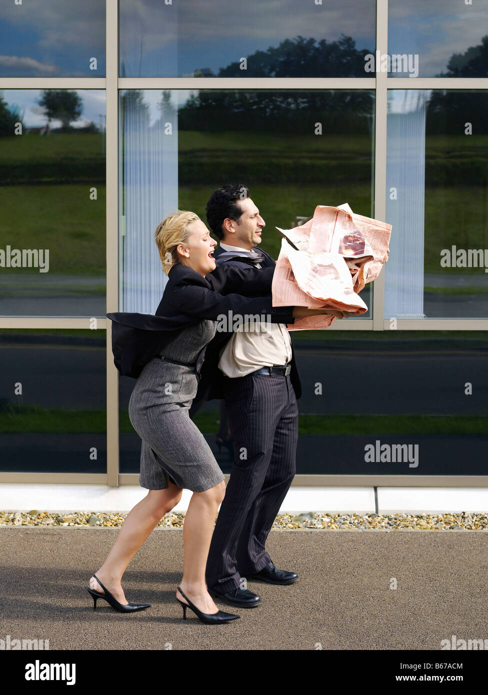 Paar kämpfen mit Zeitung Stockfoto