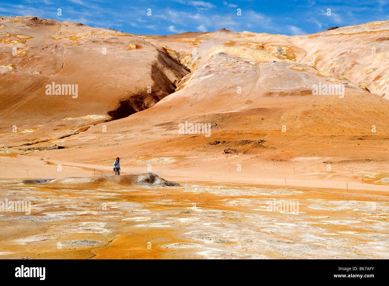 Eine Dame Tourist schaut eine Mudpot am Námafjall Geothermie Berggebiet, in der Nähe von Akureyri, Nordisland. Stockfoto