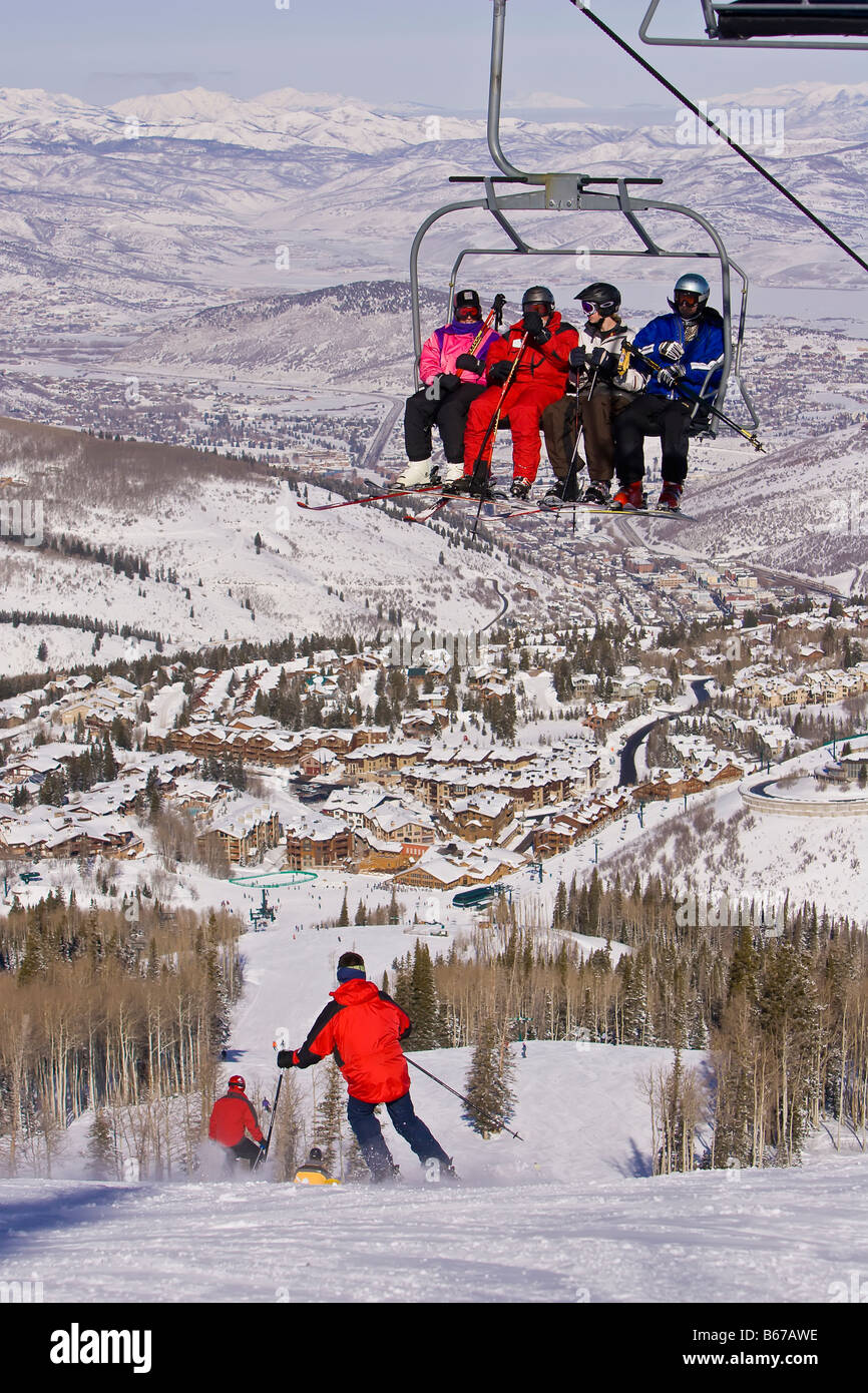 PARK CITY UTAH USA Deer Valley Resort Skigebiet Skifahrer am Sessellift mit Park City in Ferne Stockfoto