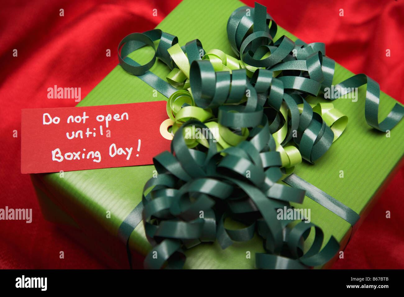 Grüne Geschenkbox auf rotem Grund Stockfoto