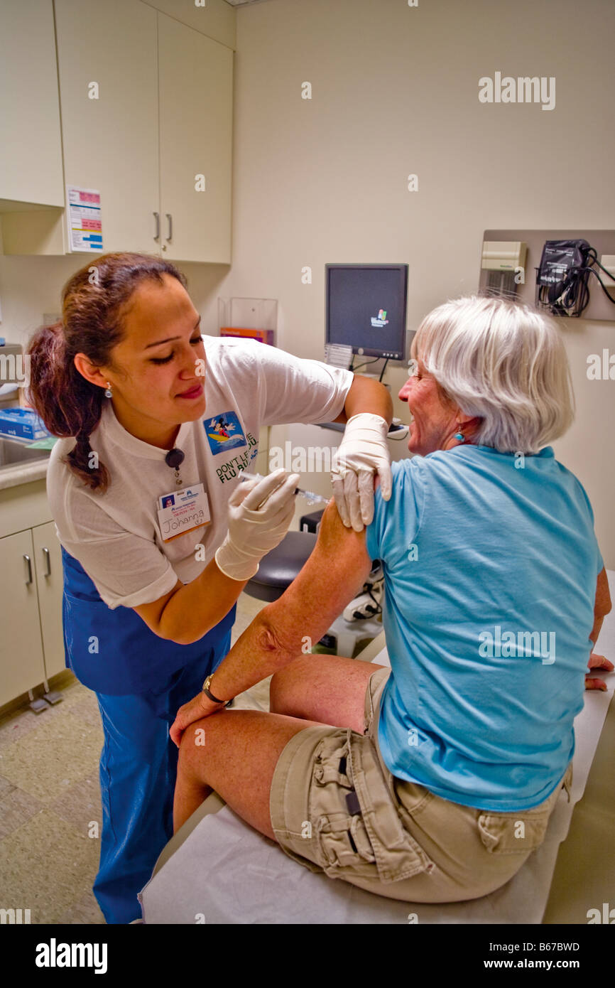 Ein Hispanic Medizintechniker verwaltet eine Grippeschutzimpfung, eine Frau mittleren Alters in einer Klinik in Südkalifornien Stockfoto