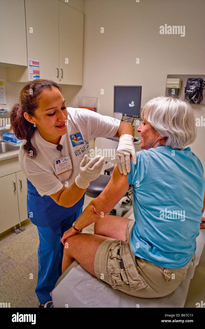 Ein Hispanic Medizintechniker verwaltet eine Grippeschutzimpfung, eine Frau mittleren Alters in einer Klinik in Südkalifornien Stockfoto