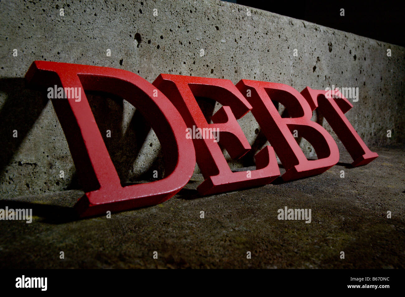 Das Wort Schulden in rot gegen Kälte konkrete Stockfoto
