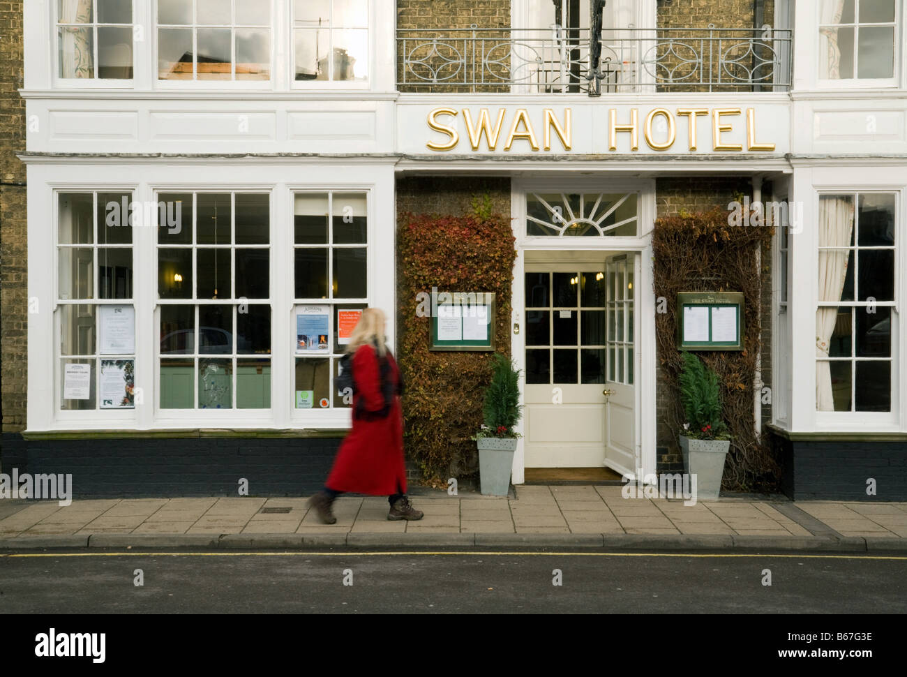 Eine Frau geht vorbei an der Einfahrt zum Swan Hotel, Southwold, Suffolk, England Stockfoto