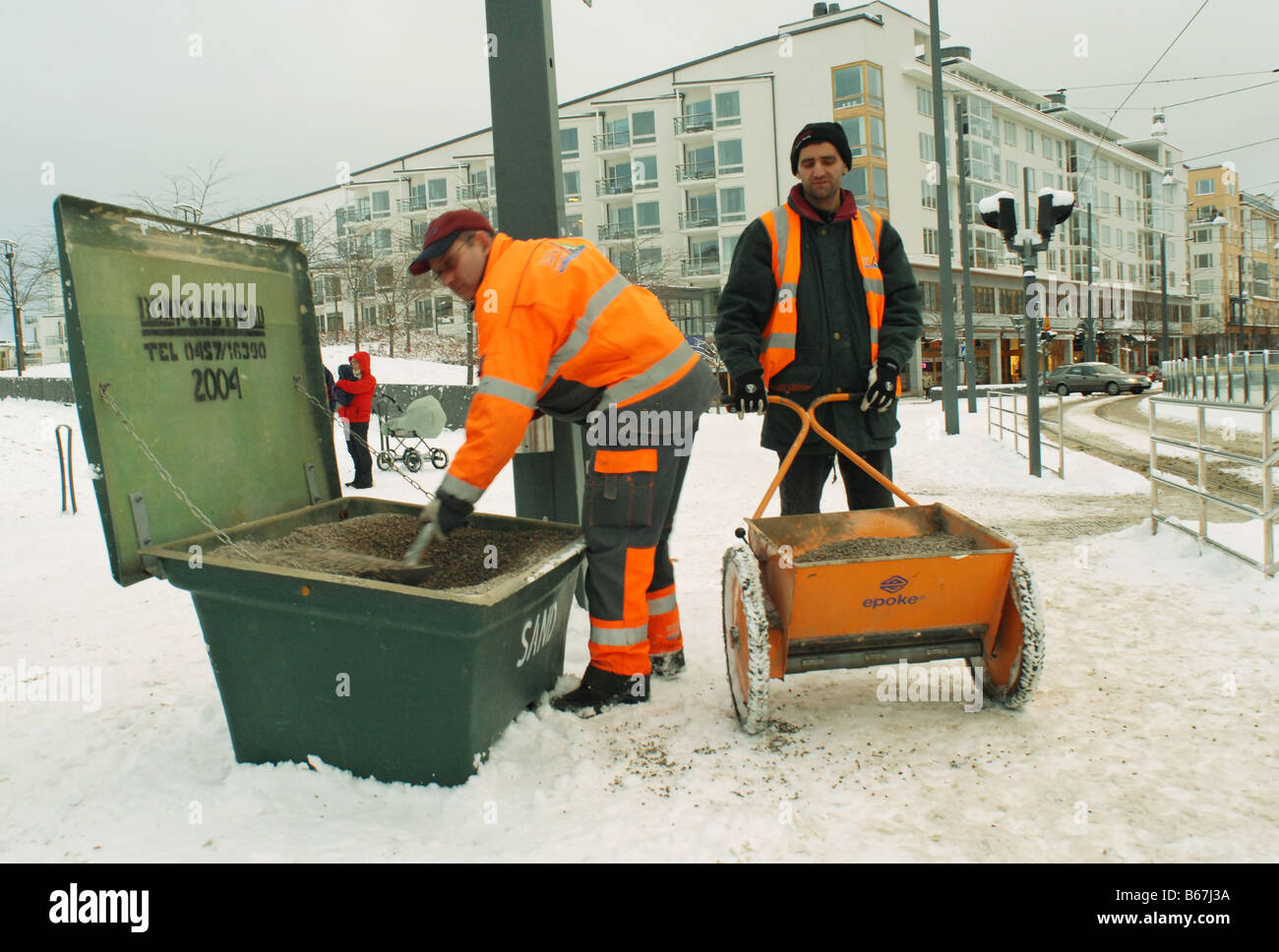 Arbeiter knirschte mit Schnee bedeckten Straßen in Hammarby Sjöstad Viertel von Stockholm in Schweden Stockfoto