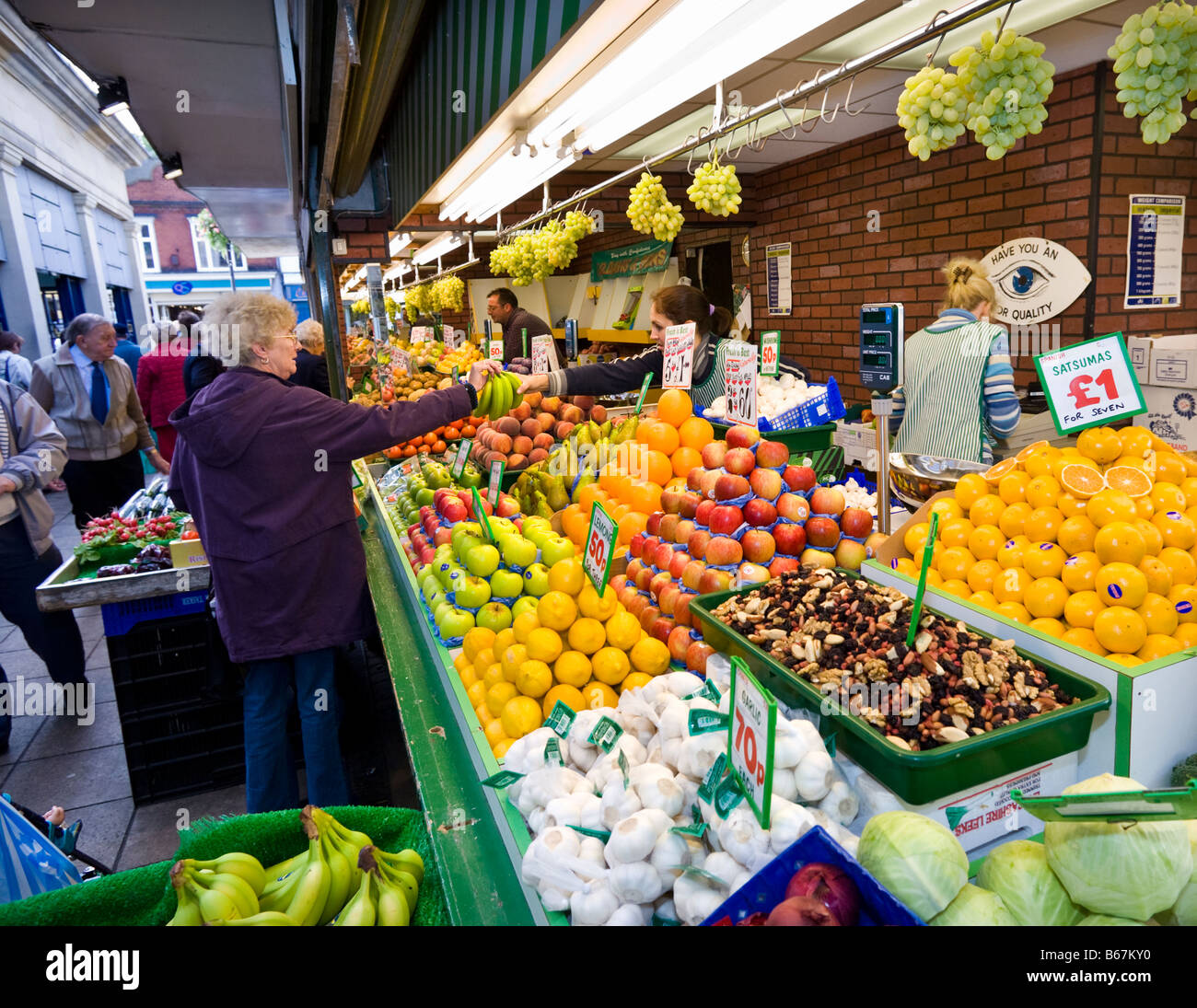 Britische Markthalle mit Kunden kaufen frisches Obst und Gemüse aus einem Stall, England, UK Stockfoto