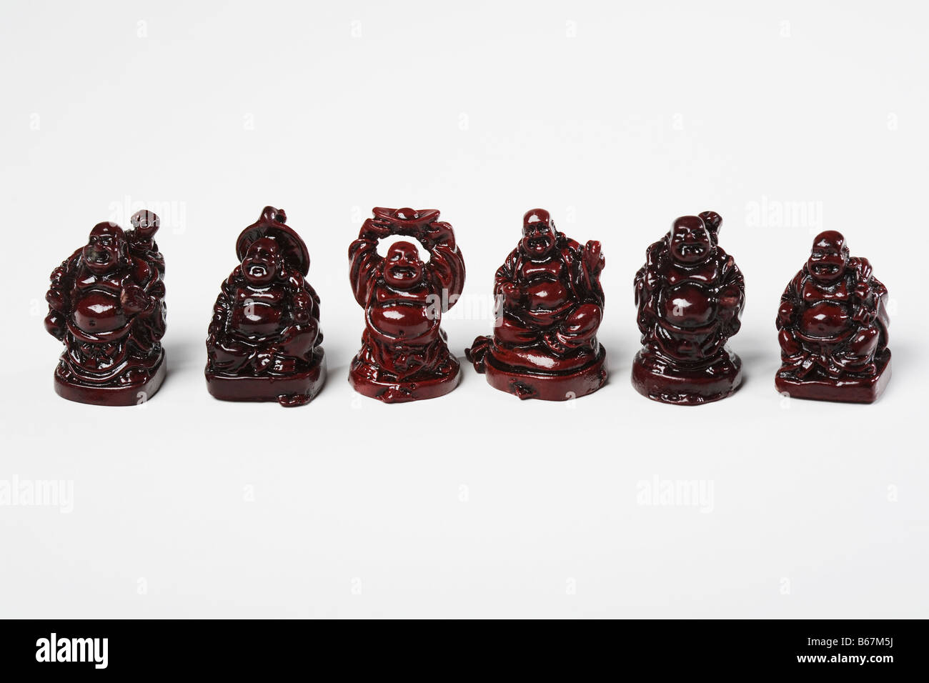 Figuren der lachende Buddha in einer Reihe vor weißem Hintergrund Stockfoto
