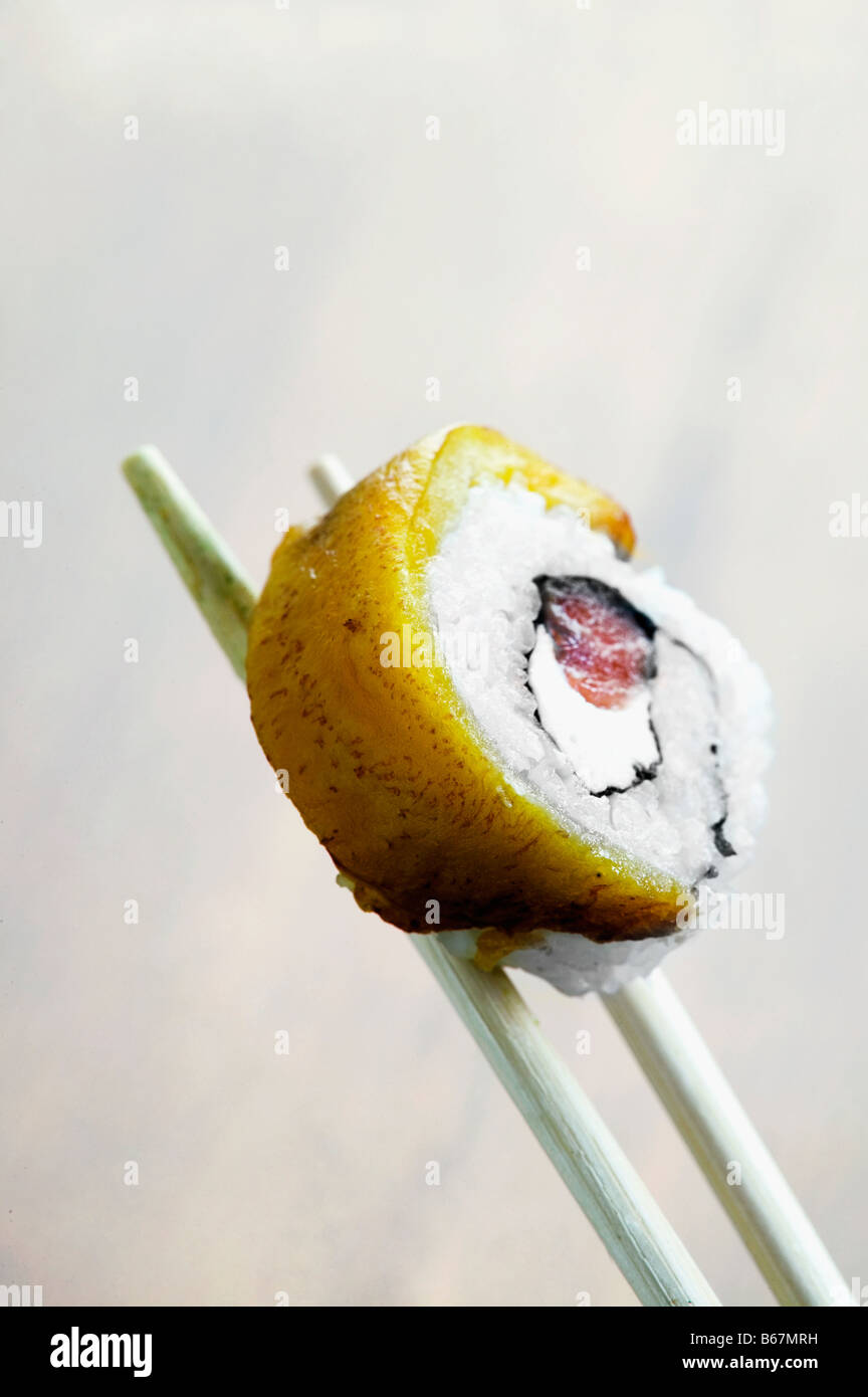 Nahaufnahme von Sushi in Stäbchen statt Stockfoto