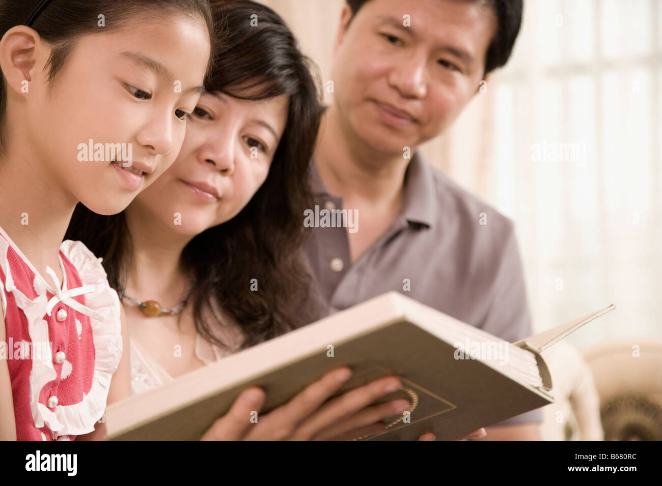 Nahaufnahme eines Mädchens, ein Buch zu lesen, mit ihren Eltern Stockfoto