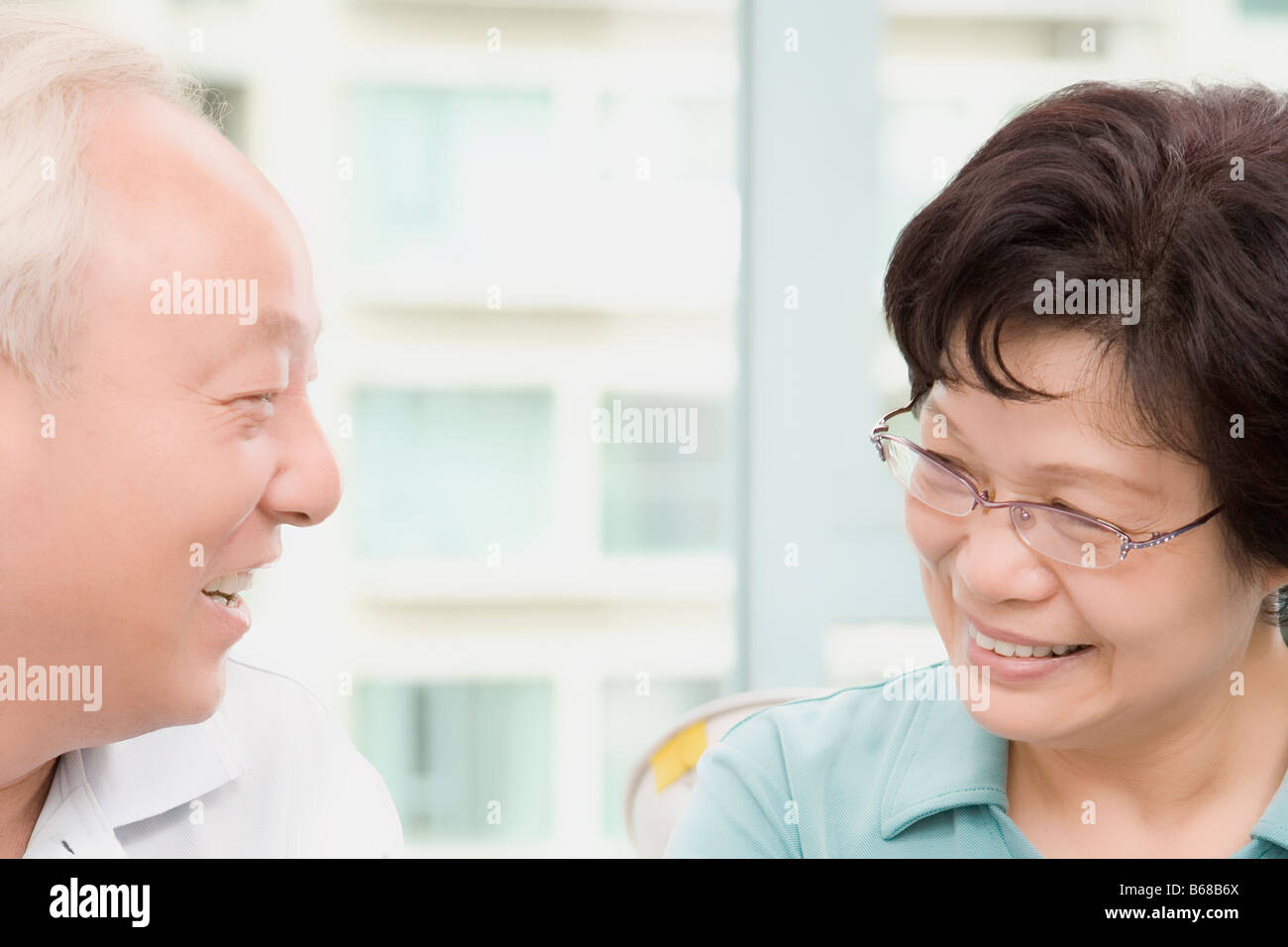 Älteres Paar einander betrachtend und lächelnd Stockfoto