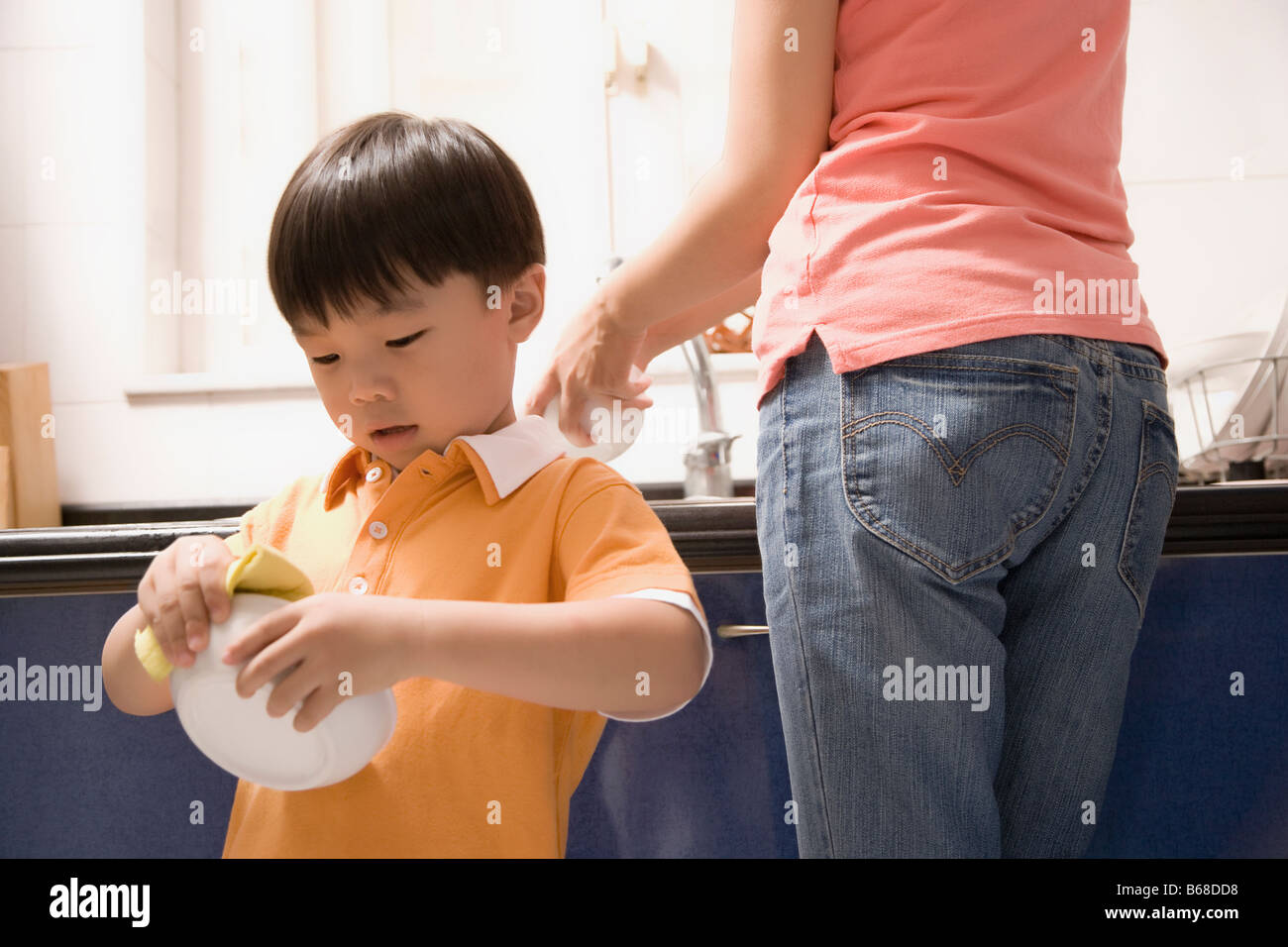 Junge seine Mutter in der Küche zu helfen Stockfoto